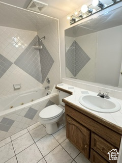 Bathroom featuring a combined bath / shower with jetted tub, visible vents, toilet, vanity, and tile patterned flooring