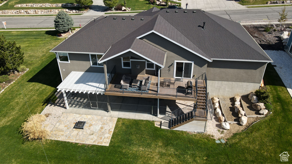 Back of property with a lawn, a deck, a patio, stairs, and stucco siding