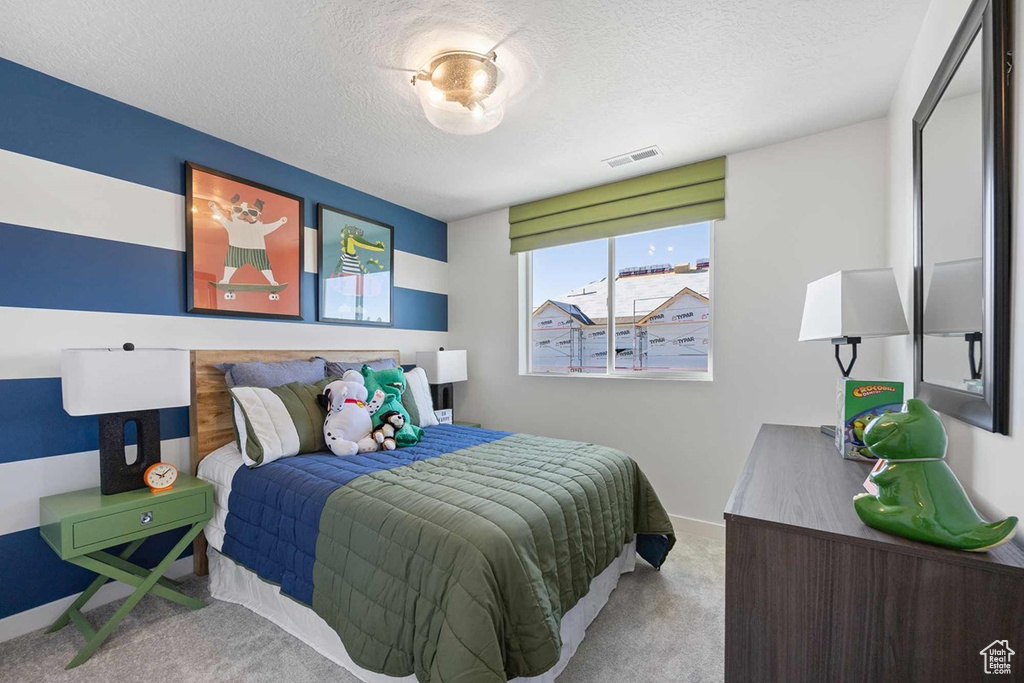 Bedroom with carpet and a textured ceiling