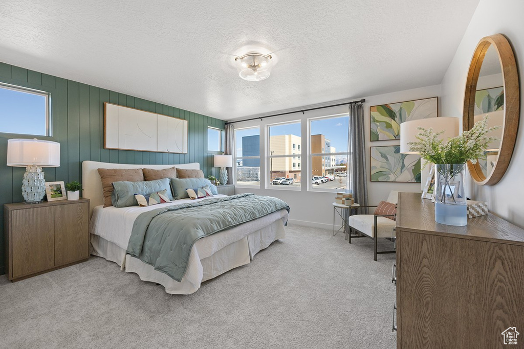 Bedroom with multiple windows, carpet flooring, and a textured ceiling
