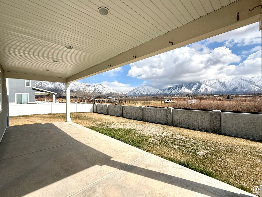 View of patio with a fenced backyard and a mountain view