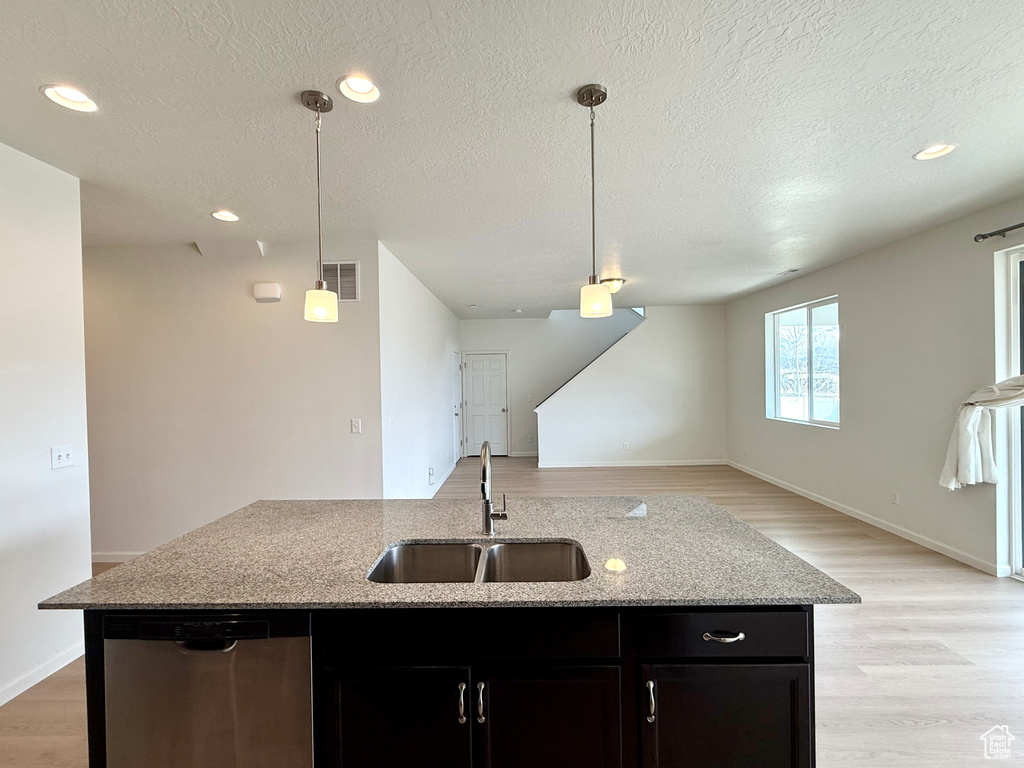 Kitchen featuring a sink, visible vents, open floor plan, and stainless steel dishwasher