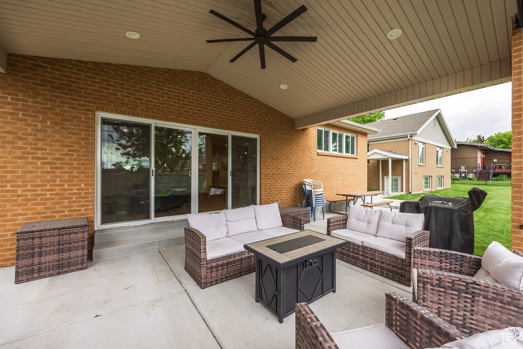View of patio with an outdoor living space with a fire pit and a ceiling fan