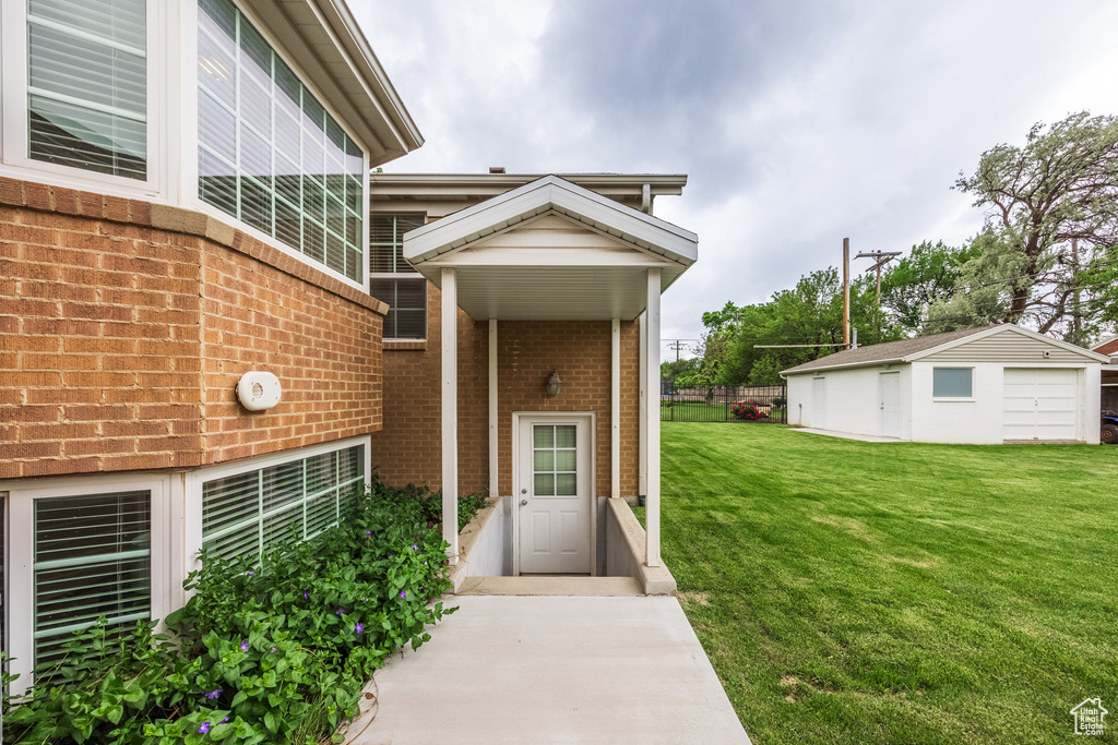 Doorway to property featuring brick siding and a yard