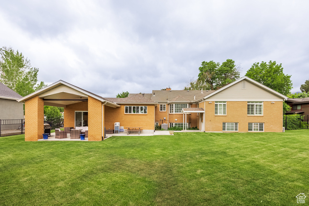 Back of house featuring outdoor lounge area, brick siding, and a patio area