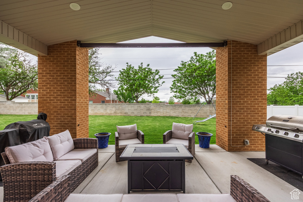 View of patio featuring grilling area and an outdoor living space with a fire pit