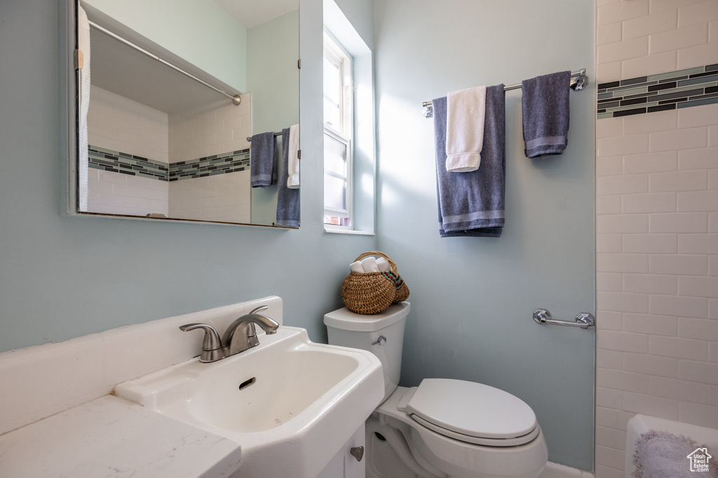 Bathroom with toilet, a sink, and a shower