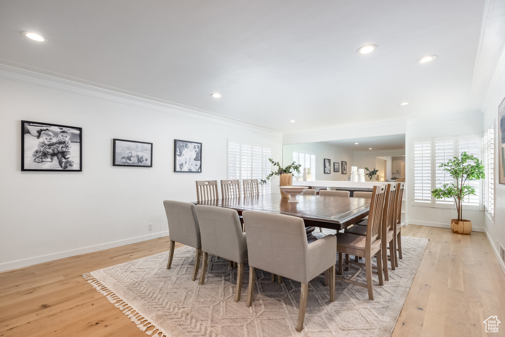 Dining room featuring ornamental molding, light wood finished floors, baseboards, and recessed lighting