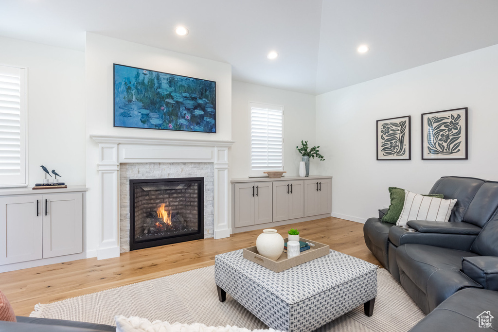 Living room with light wood-style flooring, a fireplace, recessed lighting, and baseboards