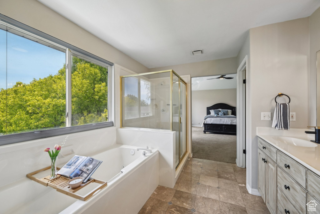 Bathroom with vanity, a bath, a shower stall, ceiling fan, and stone finish flooring
