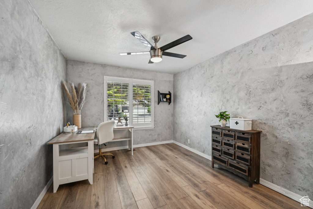 Office space featuring wood finished floors, a ceiling fan, and baseboards