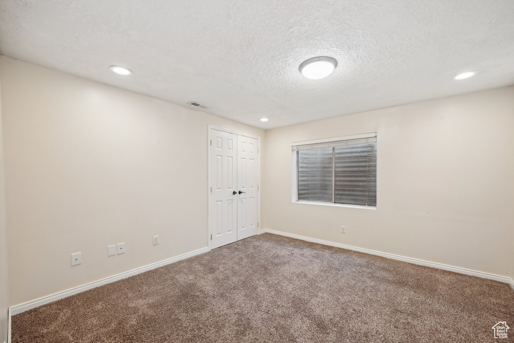 Unfurnished room featuring carpet flooring, a textured ceiling, baseboards, and recessed lighting
