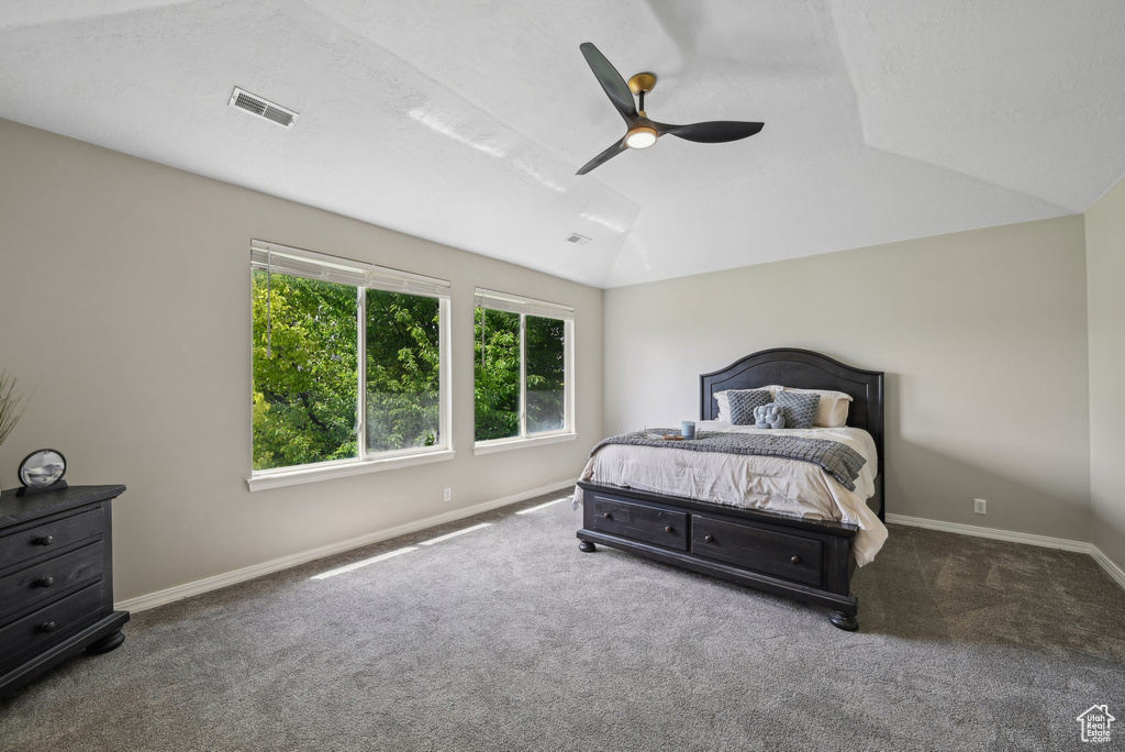 Bedroom with carpet floors, baseboards, vaulted ceiling, and ceiling fan