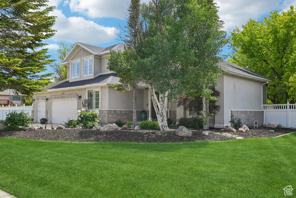 View of front of house featuring stucco siding, stone siding, a shingled roof, and an attached garage