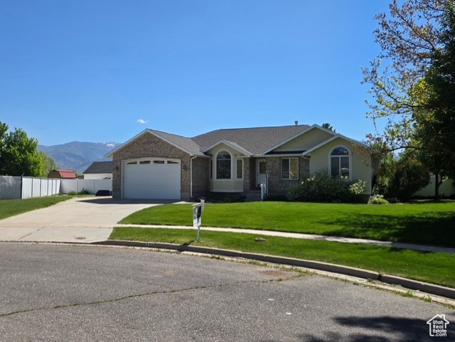 Ranch-style house with concrete driveway, a garage, and a mountain view