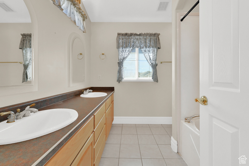 Bathroom featuring visible vents, a sink, and tile patterned floors