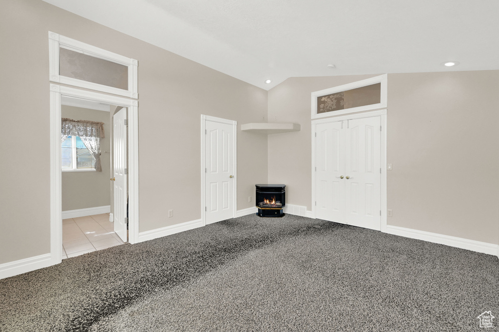 Interior space with lofted ceiling, carpet floors, and baseboards