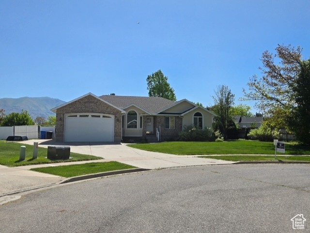 Single story home featuring an attached garage, driveway, and a mountain view