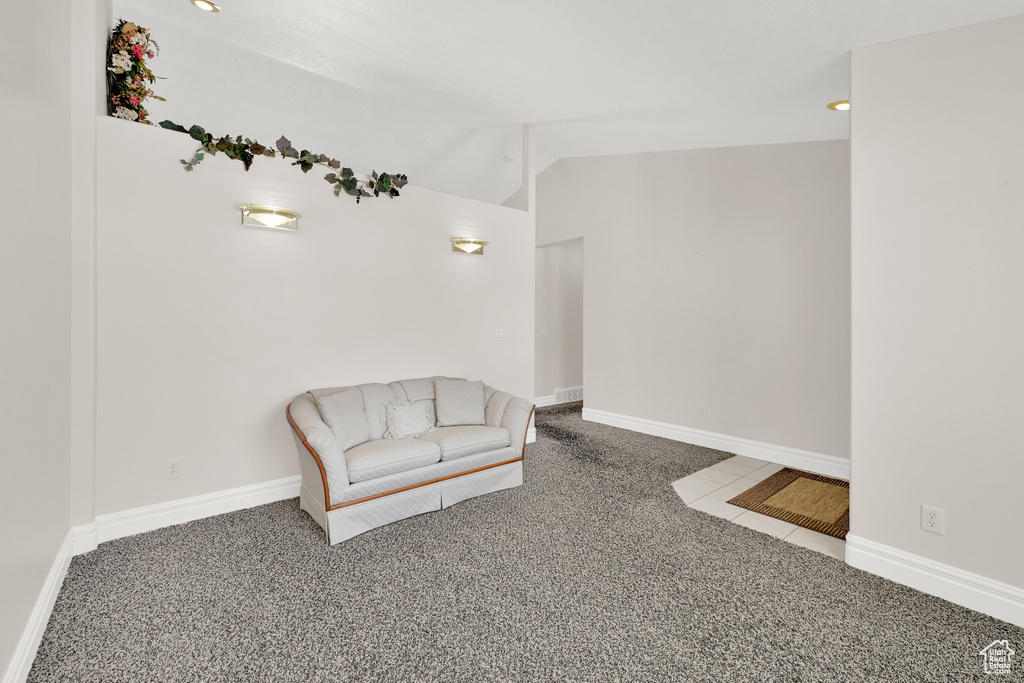 Unfurnished room with lofted ceiling, tile patterned flooring, baseboards, and carpet flooring