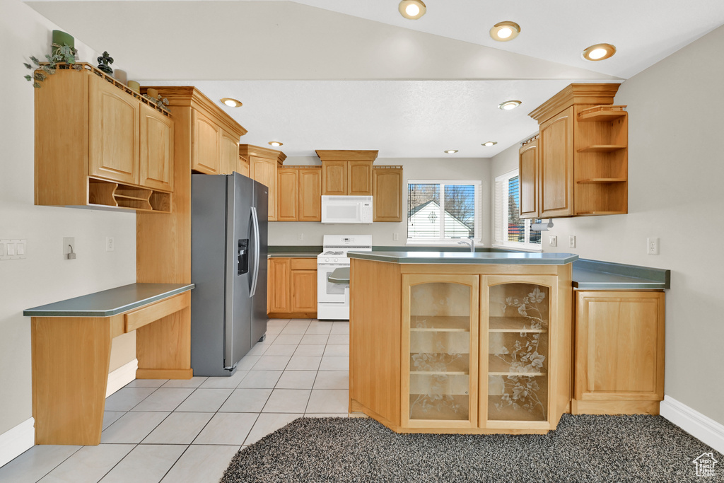 Kitchen with white appliances, light tile patterned floors, glass insert cabinets, a peninsula, and open shelves