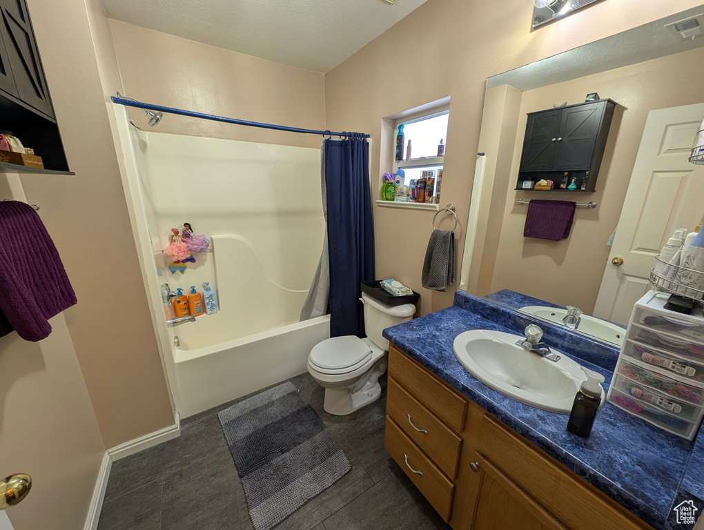 Full bathroom with shower / tub combo with curtain, visible vents, toilet, vanity, and baseboards