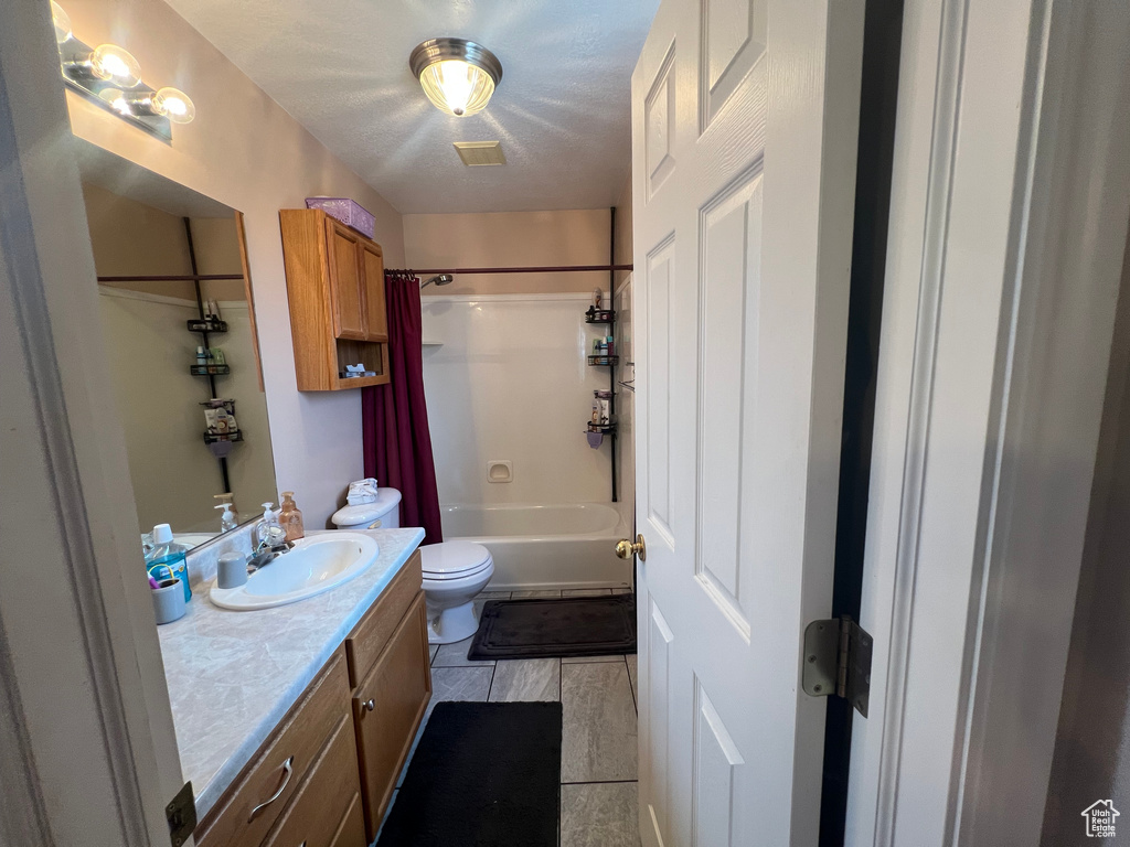 Full bath featuring toilet, shower / bath combo, and vanity