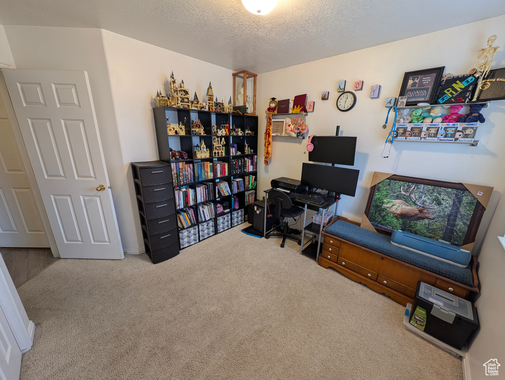 Home office featuring a textured ceiling and carpet