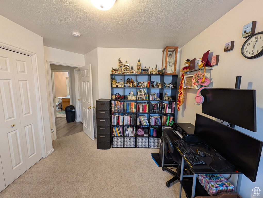 Home office with carpet floors and a textured ceiling