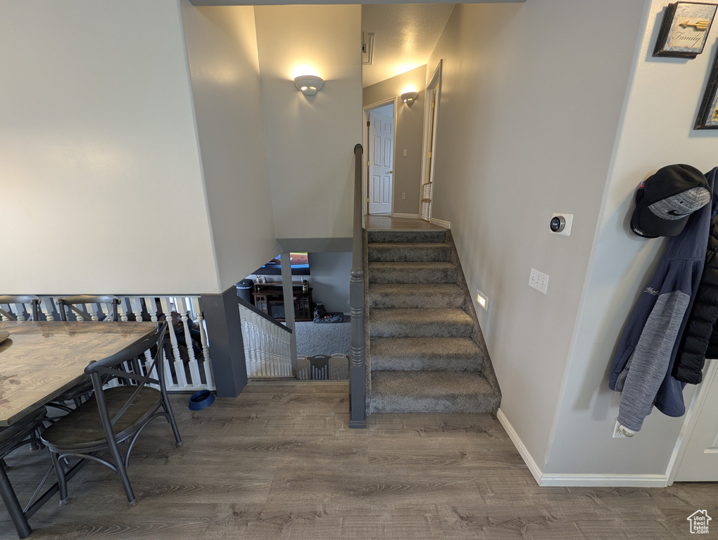 Stairway featuring baseboards and wood finished floors