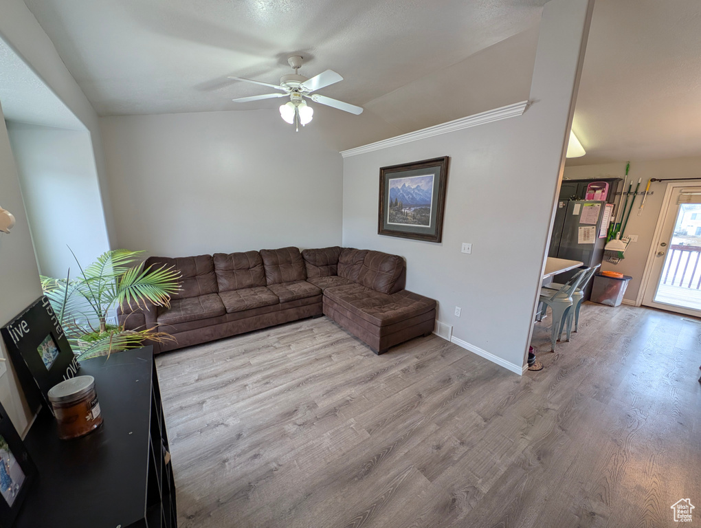 Living area with ceiling fan, baseboards, and wood finished floors