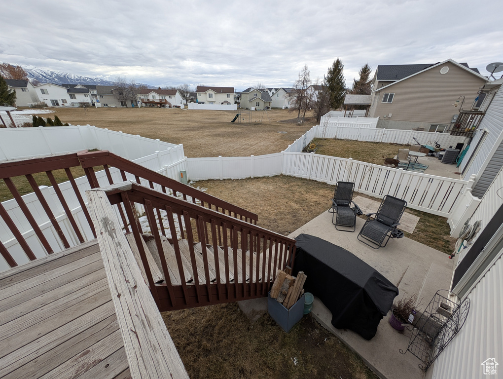 Wooden terrace with a patio area, a fenced backyard, and a residential view