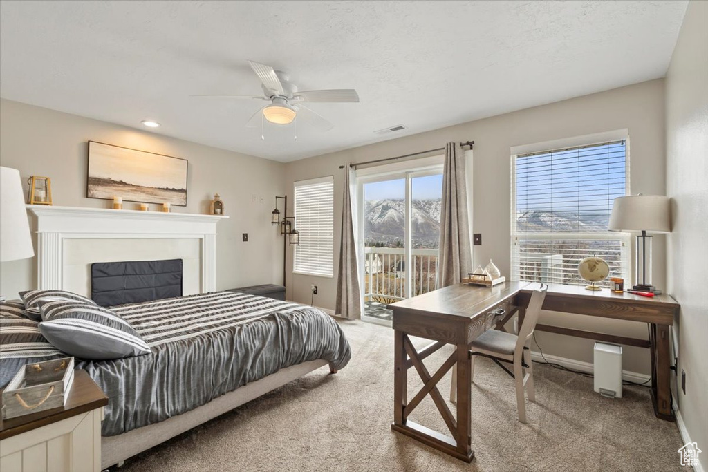 Carpeted bedroom featuring baseboards, visible vents, a ceiling fan, access to exterior, and a fireplace