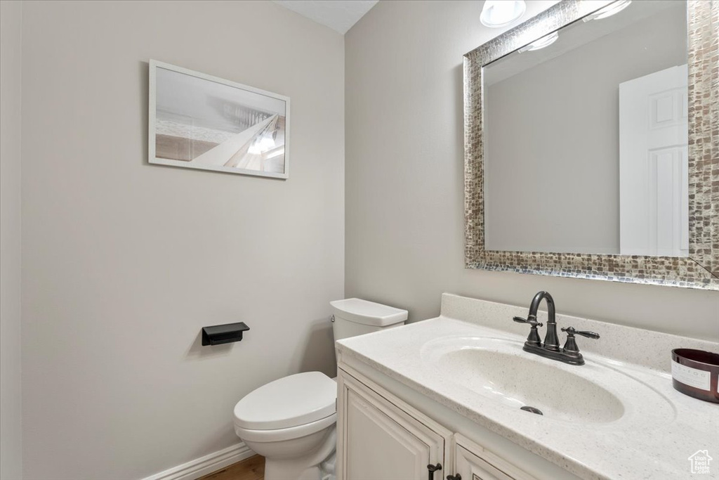 Bathroom with toilet, baseboards, and vanity