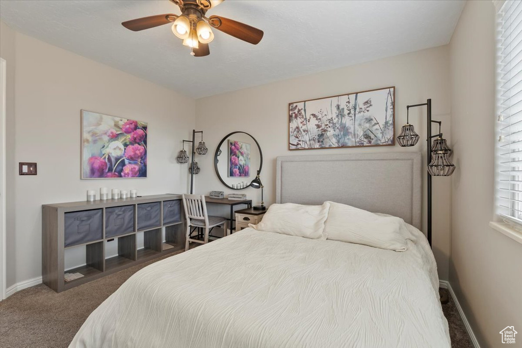 Bedroom featuring baseboards, dark carpet, and ceiling fan