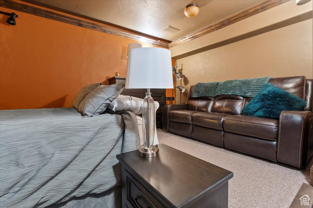 Bedroom featuring carpet flooring and a textured wall