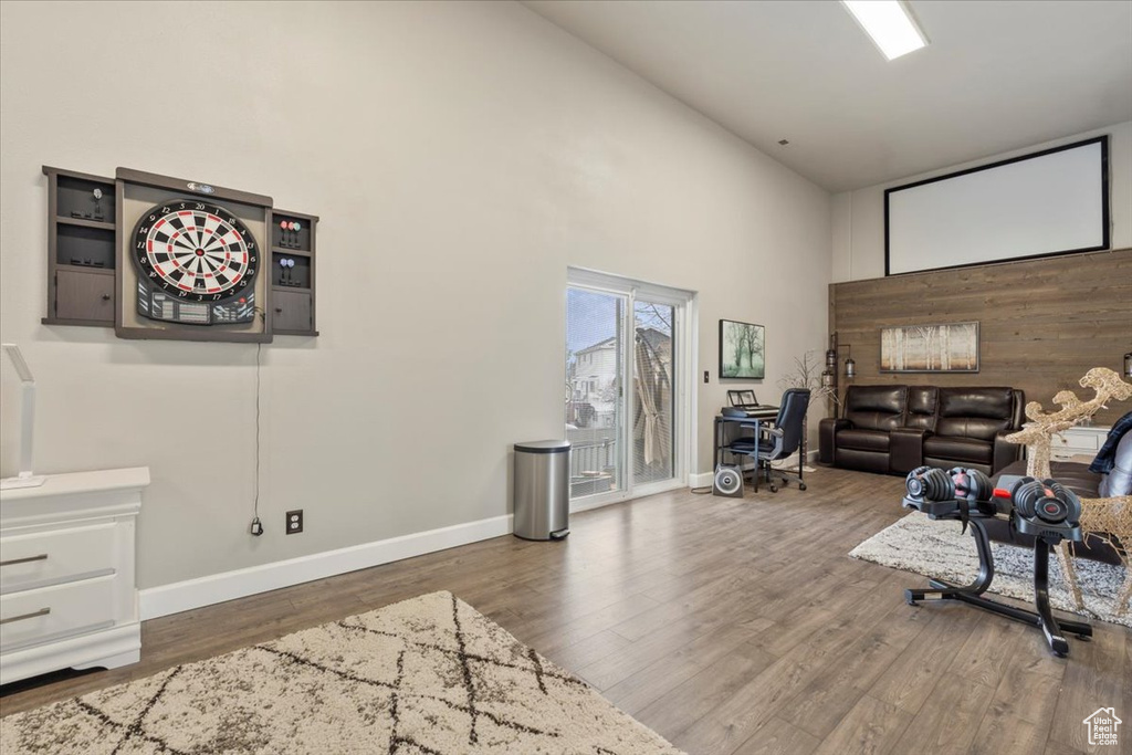 Living room featuring high vaulted ceiling, baseboards, and wood finished floors