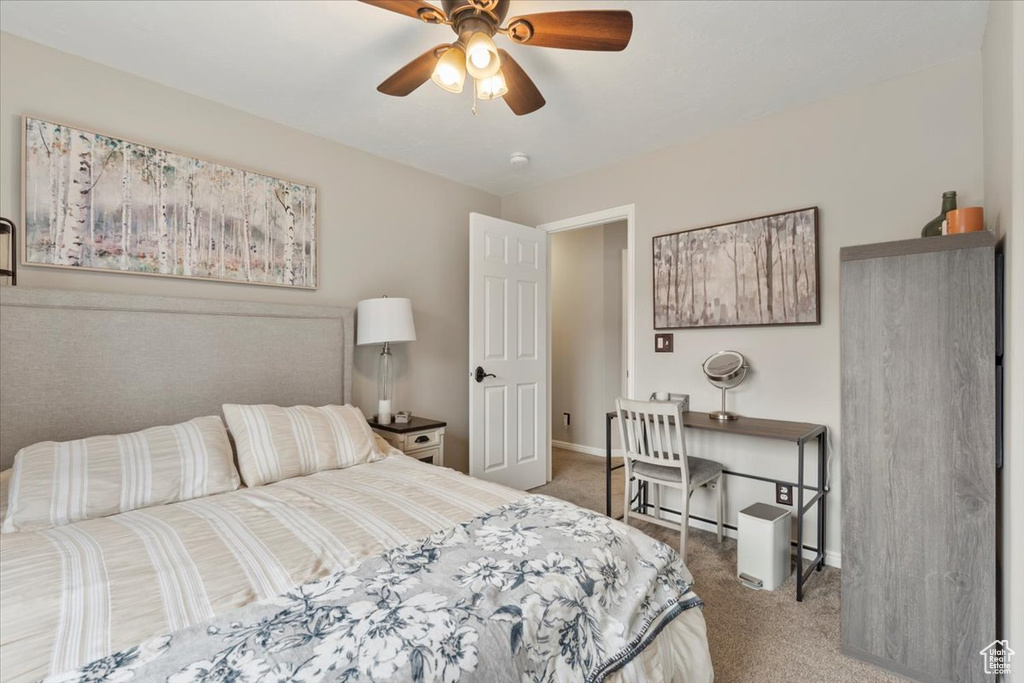 Carpeted bedroom featuring ceiling fan and baseboards