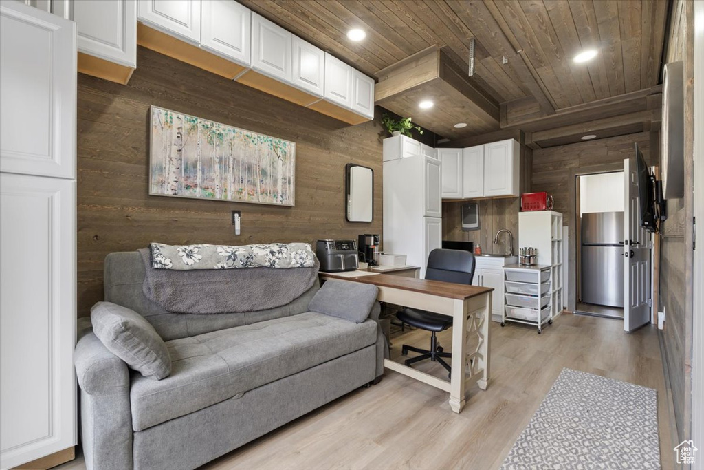 Interior space featuring wood ceiling, white cabinetry, and wood walls