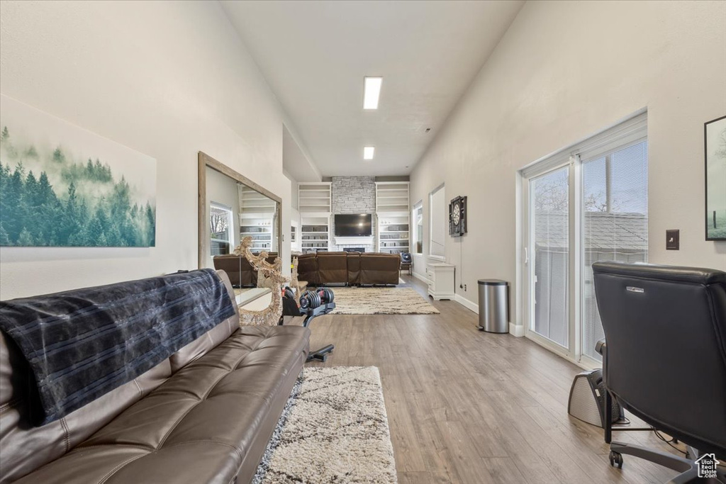 Living room with a towering ceiling, baseboards, and wood finished floors