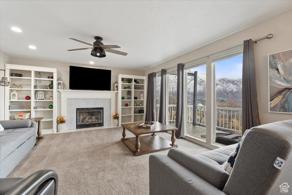 Living room featuring a fireplace with flush hearth, recessed lighting, carpet floors, and a ceiling fan