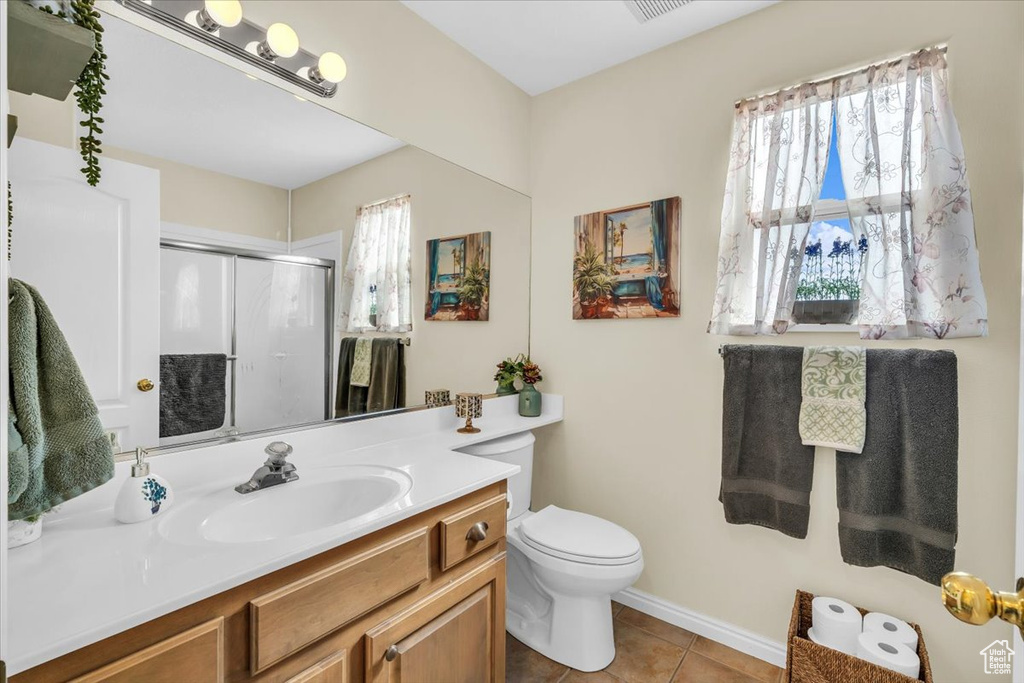 Full bath featuring visible vents, toilet, tile patterned floors, vanity, and a shower stall