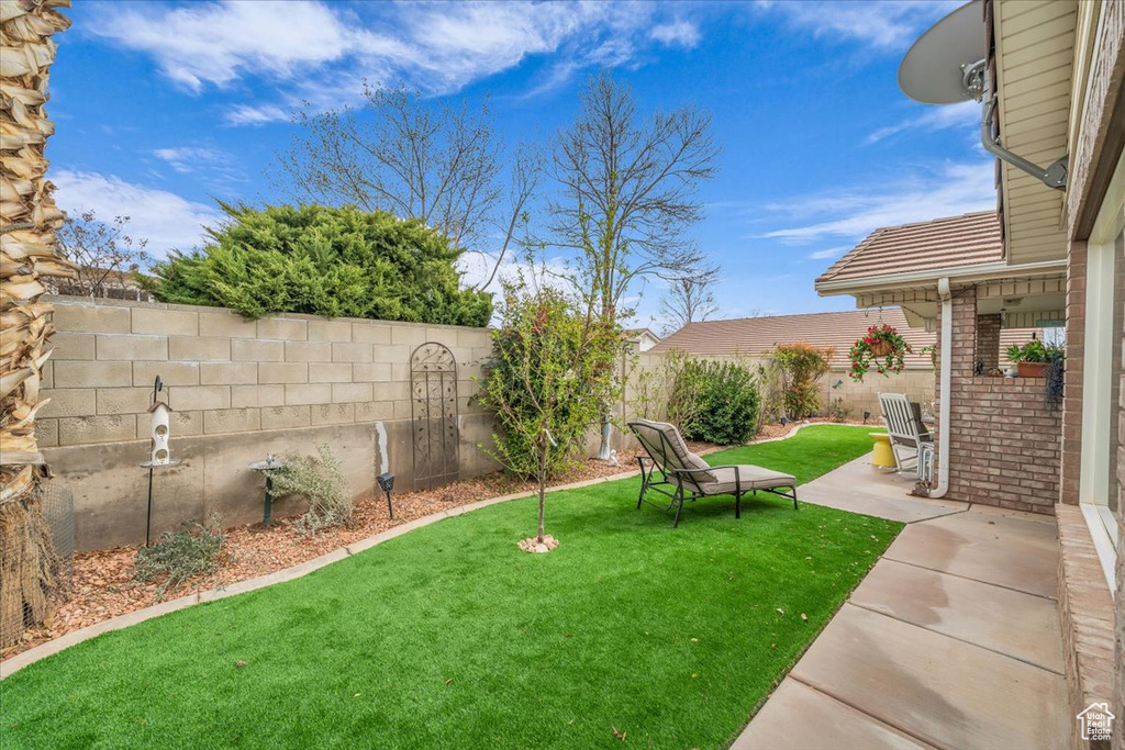 View of yard with a fenced backyard and a patio