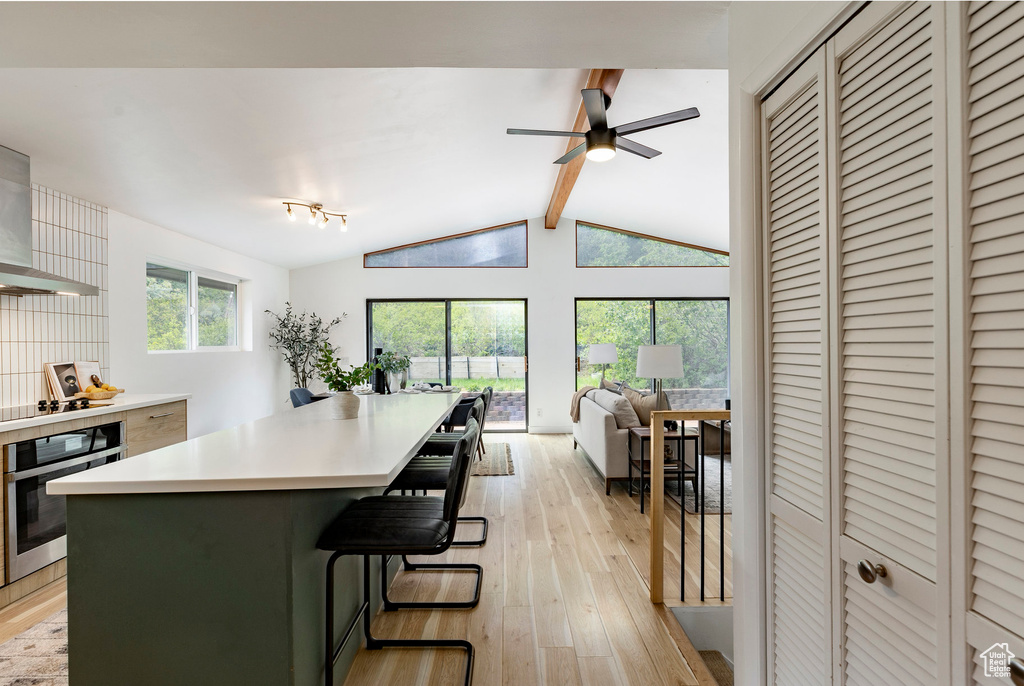 Kitchen with oven, light wood-style floors, open floor plan, and light countertops