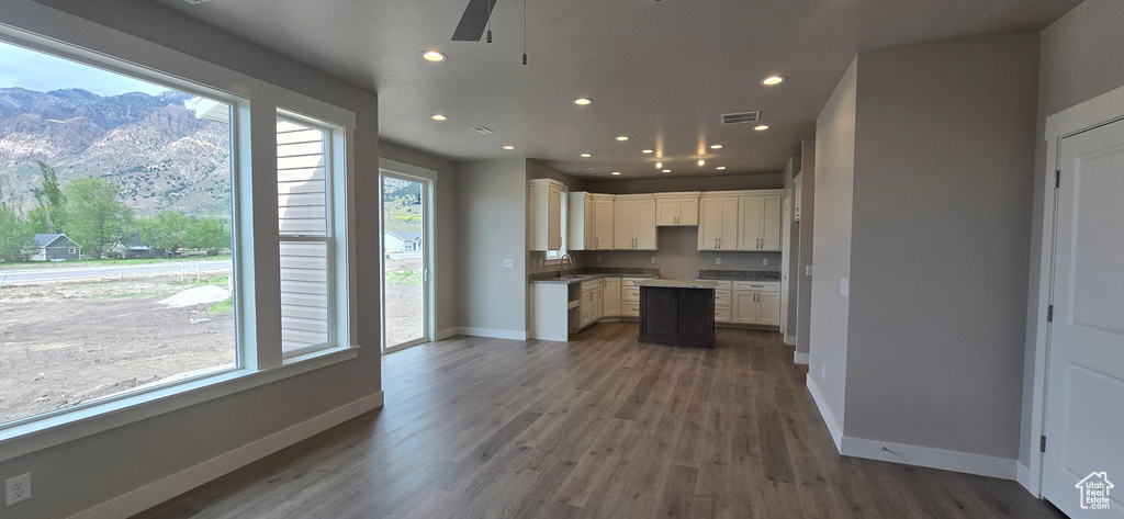 Kitchen with a ceiling fan, baseboards, a healthy amount of sunlight, and a mountain view