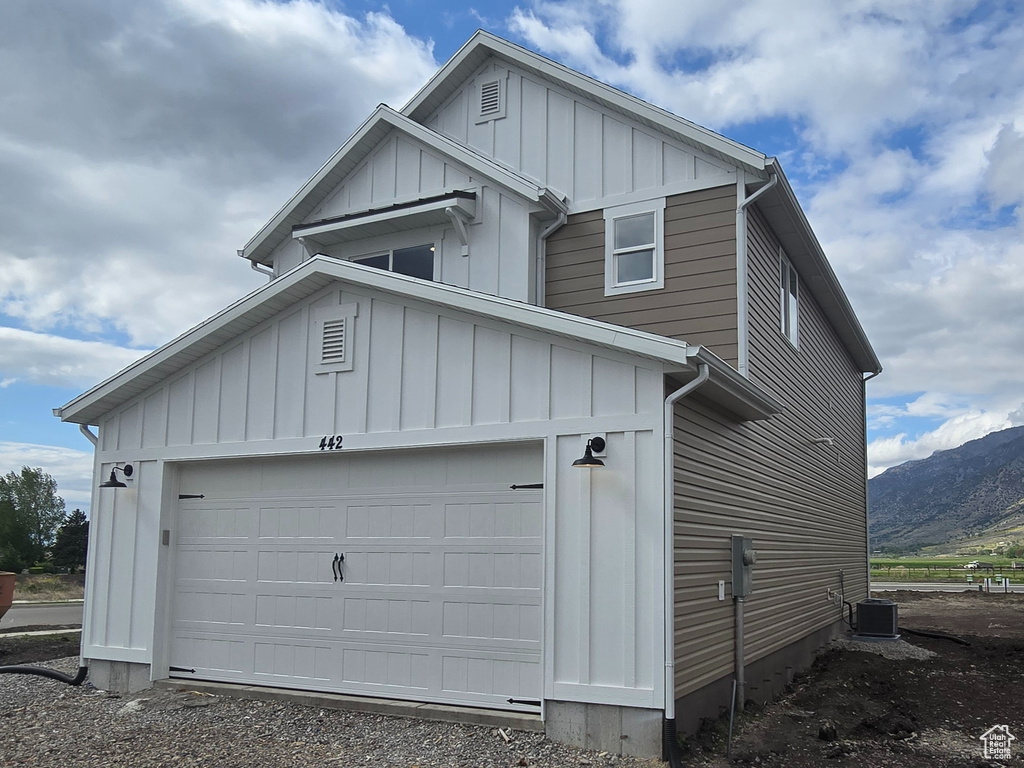 Garage with gravel driveway and a mountain view