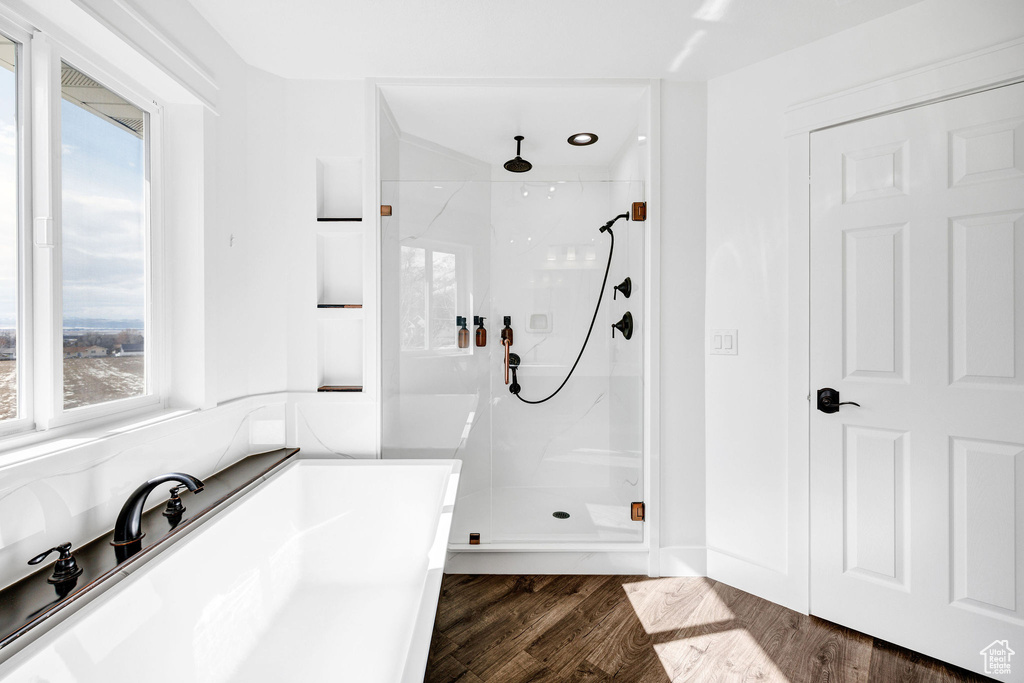 Full bath featuring a stall shower and wood finished floors