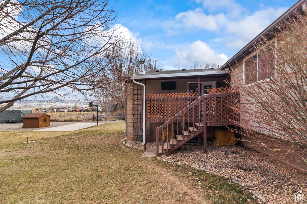 View of yard featuring stairs, a deck, and an outdoor structure