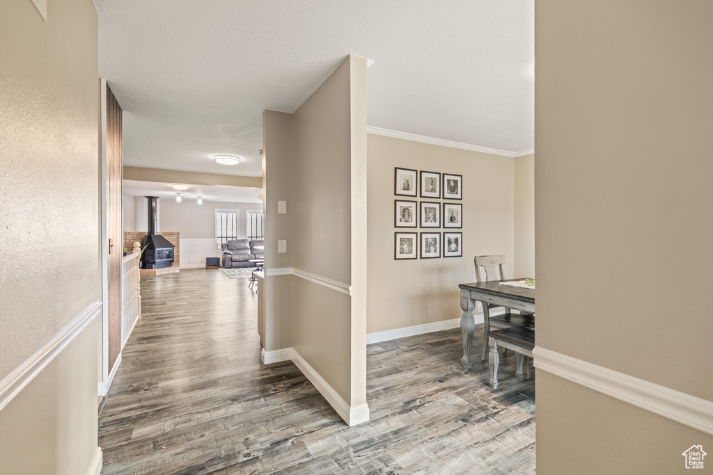 Corridor featuring ornamental molding, baseboards, and wood finished floors