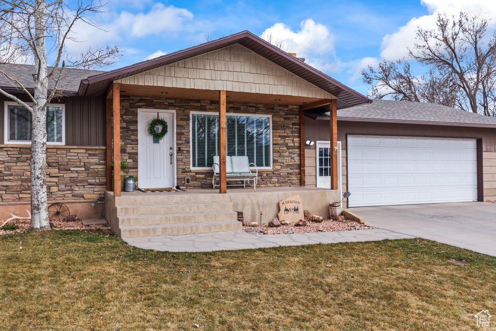 Ranch-style house with a garage, concrete driveway, roof with shingles, covered porch, and a front lawn