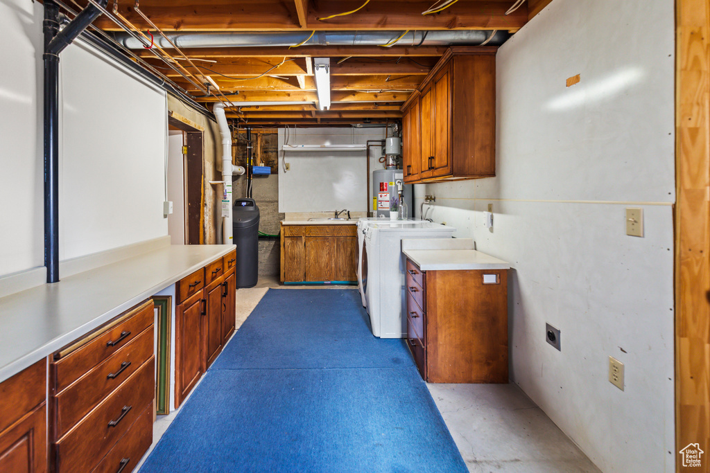Interior space featuring independent washer and dryer, gas water heater, and a sink